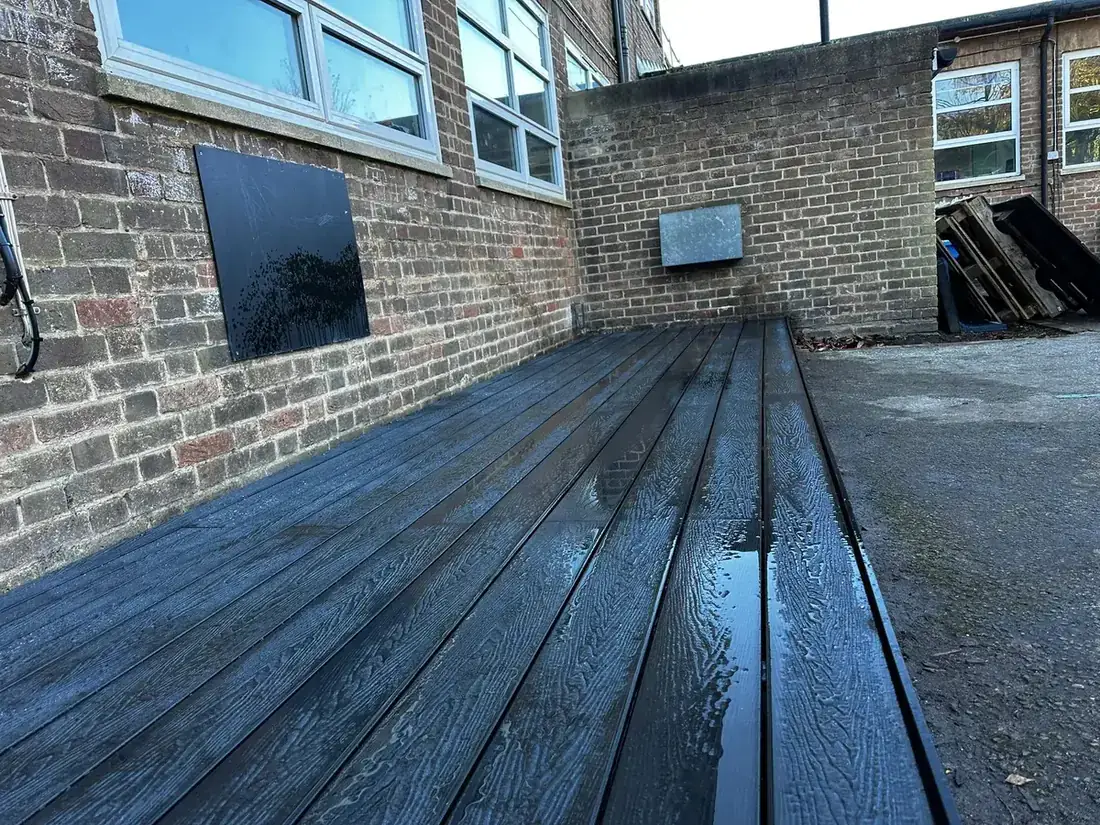 Composite decking platform running alongside a brick building