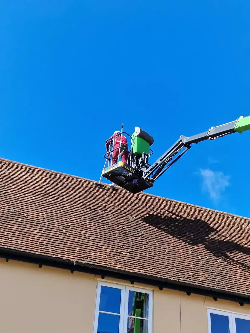Powered access platform in use at a roofline