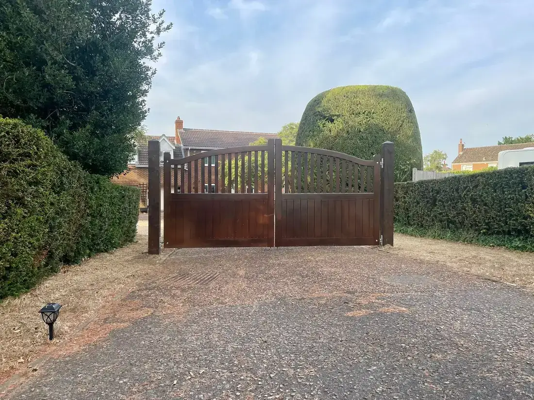 Double timber driveway gates fitted between hedges